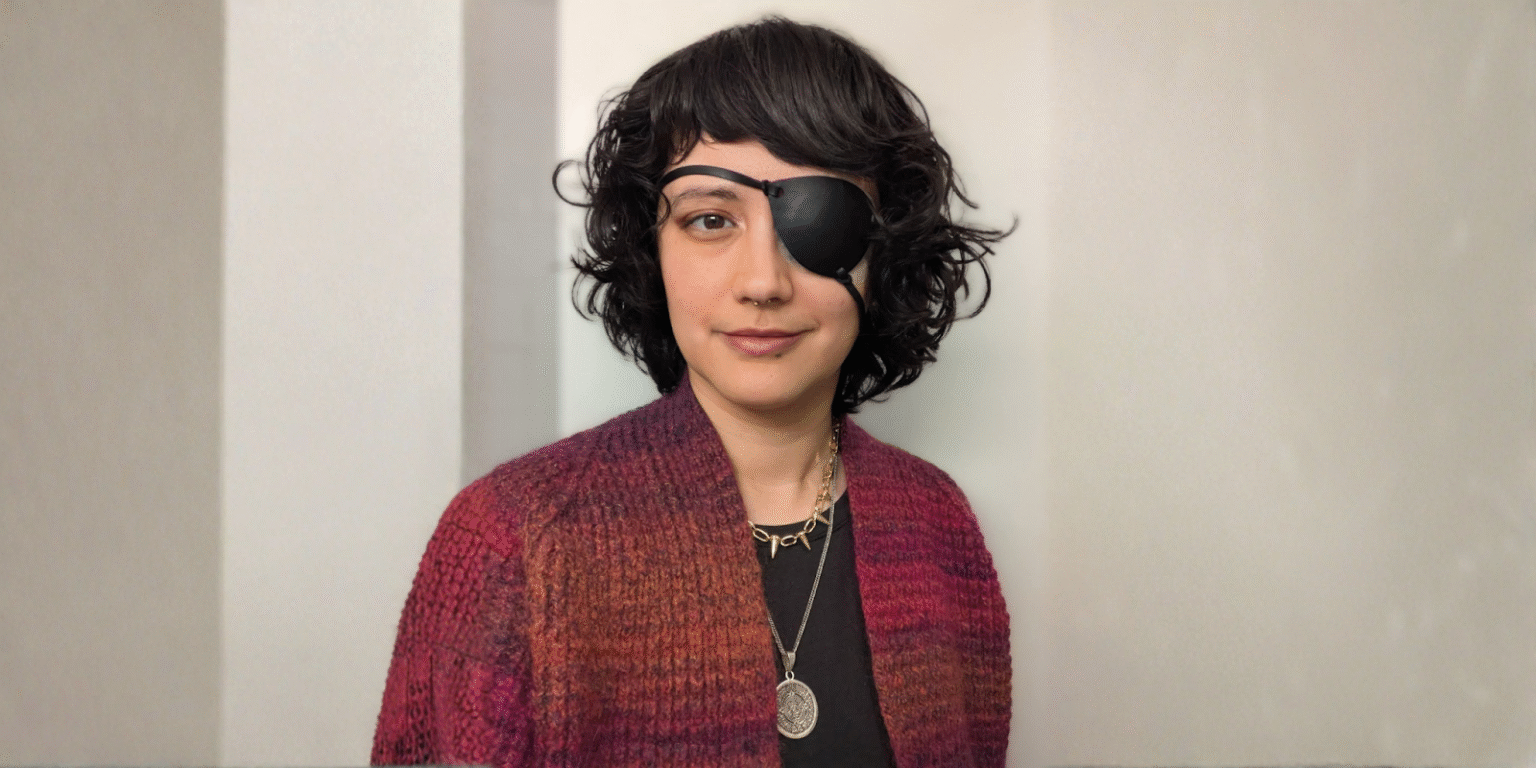 Blind in One Eye, Vision for a New World: The Disabled Artist Reimagining Aztec Myth Abigail Roscoe, a disabled artist, wearing an eye patch, showcasing her unique style and resilience.