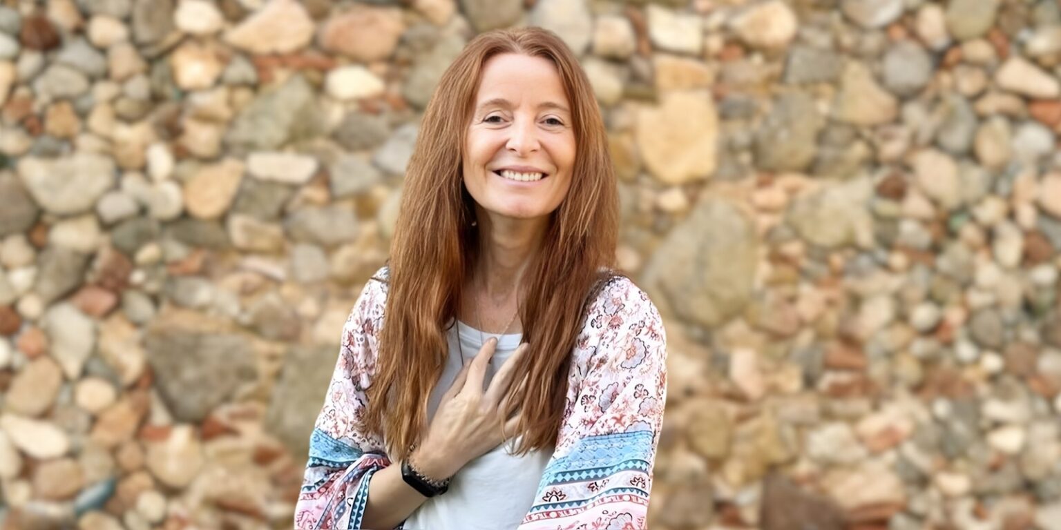 Sandra Gali Rogent: Leading with Awareness, Creativity, and Integrity Sandra Gali Rogent smiles confidently, embodying creativity and authenticity with a backdrop of stones, reflecting mindful leadership and transformation.