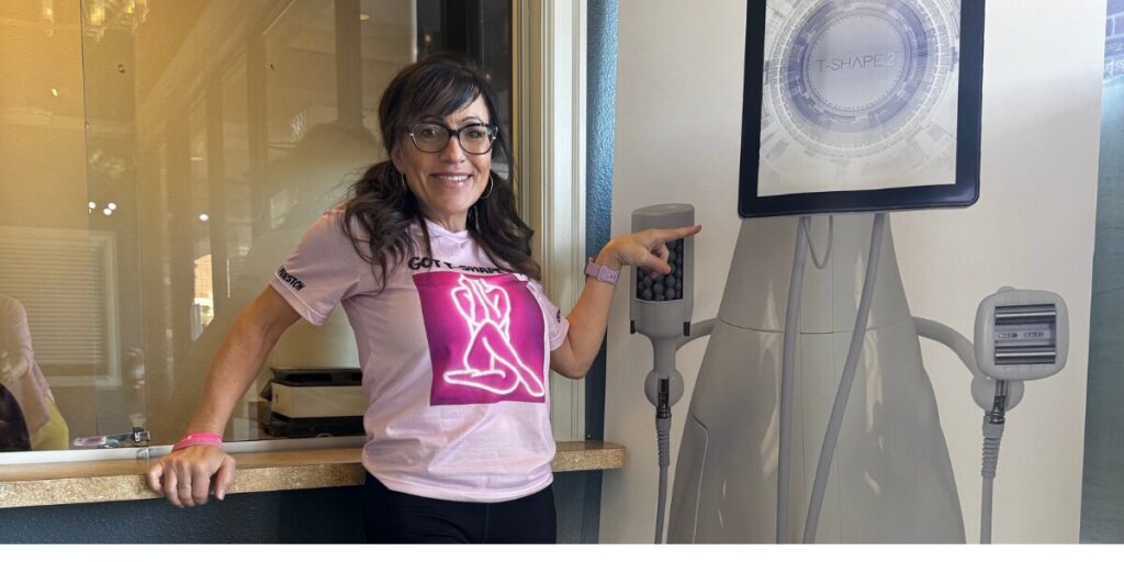Belinda Preston, founder of Studio B Spa and More, standing next to a T-SHAPE 2 device, smiling.