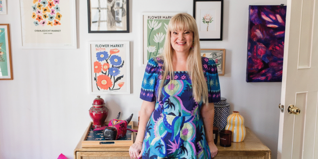 Nikki Smit standing in front of colorful artwork, promoting emotional resilience and mental wellness.