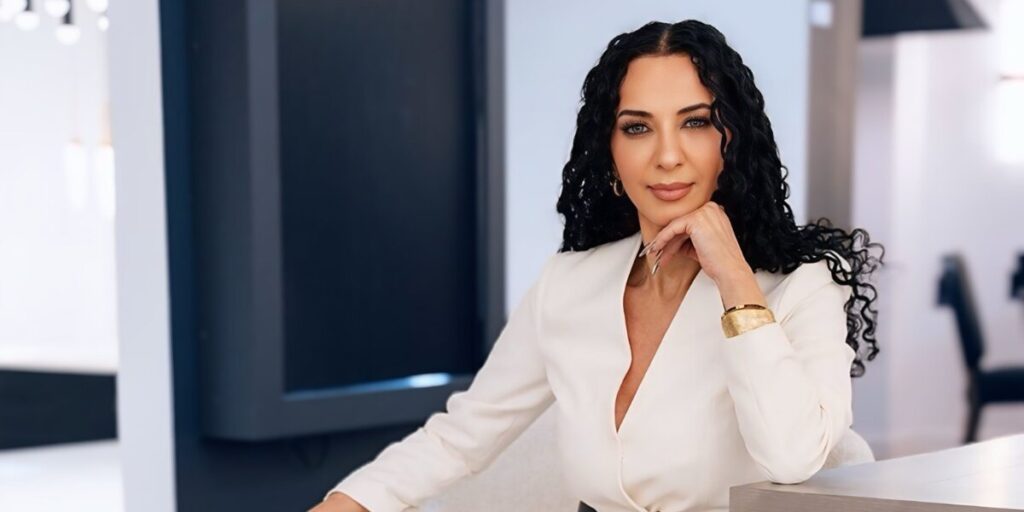 Klaudia Zinaty, founder of Women Empowerment Awards, exuding confidence in a white blouse, embodying leadership and empowerment