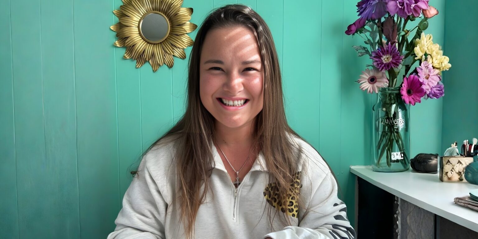 Transform Heal Grow: Alicia Rios Liberates Voices A girl smiles while holding a cup of coffee, embodying warmth and joy in a moment of personal reflection.