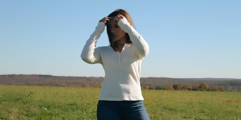 Hailey Howell models Hails denim outdoors, blending individuality, culture, and creative storytelling against a peaceful natural landscape and open sky.