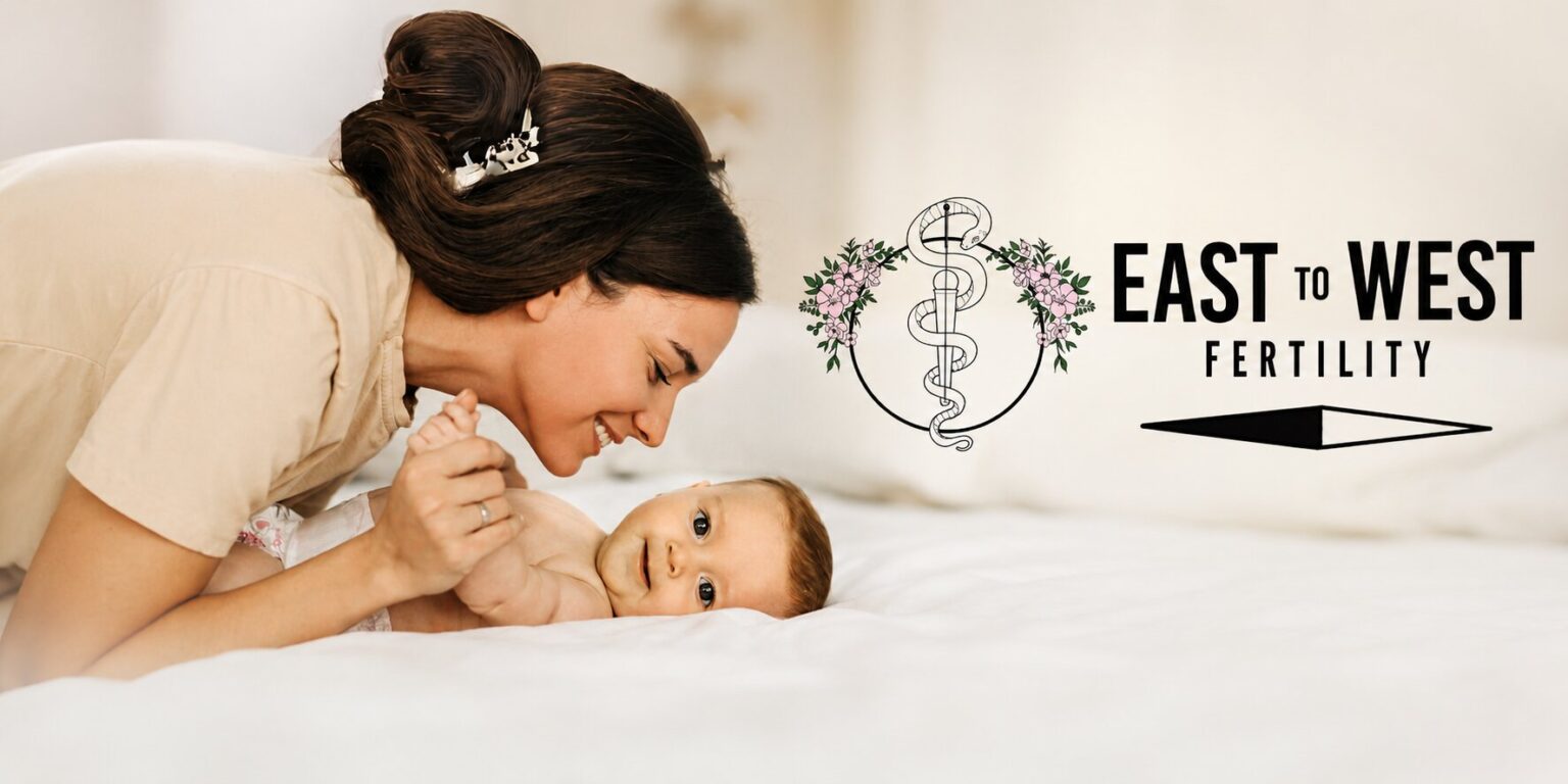 Mother smiling at baby beside East to West Fertility logo, representing personalized fertility care and family-building.