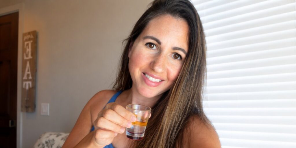 Michelle Unger Helps Women and Mothers Find a More Informed Start Michelle Unger holds a small wellness shot, representing her informed, test-first approach to everyday wellness.