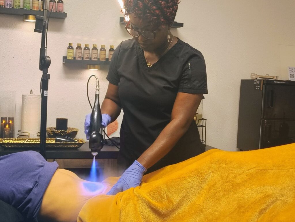 Nurse Olu performing a non-invasive body contouring treatment on a client.