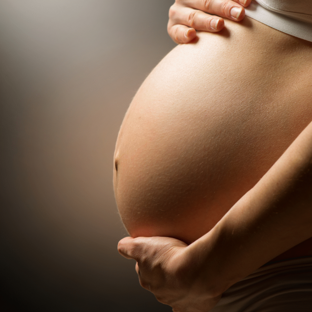 Close-up of pregnant belly with hands, symbolizing healthy pregnancy and maternal care.