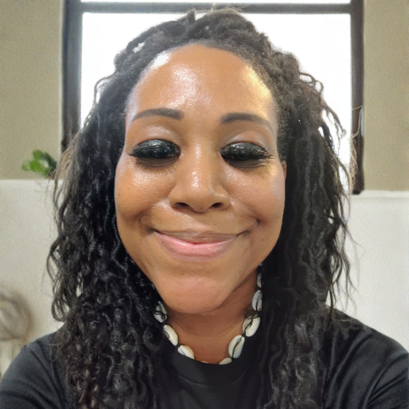 Smiling portrait of artist Shantress Nicole wearing a shell necklace, representing the contemporary Afrocentric visual storyteller.