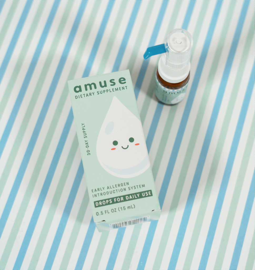 Amuse Drops box and bottle for early allergen introduction on a blue striped background.