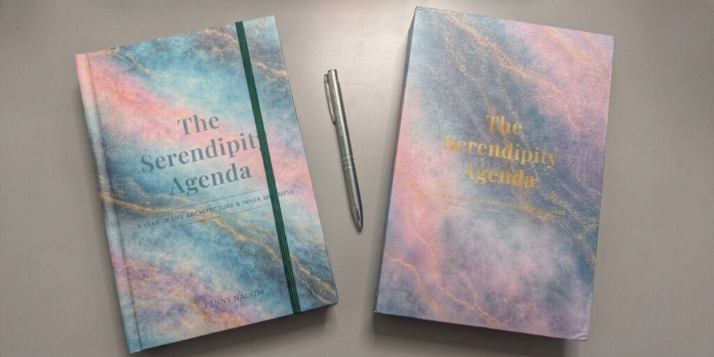 The Serendipity Agenda Helps Women Escape Digital Overload Two editions of The Serendipity Agenda displayed beside a silver pen.