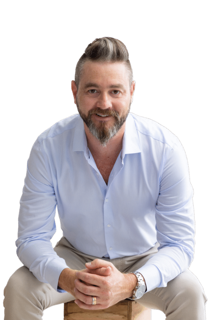 Bart Jarvis seated in a light blue shirt with hands clasped, smiling at the camera.
